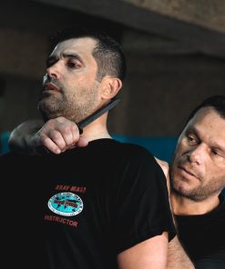 Treinador de Krav Maga ensina técnica de defesa contra ameaça com faca.